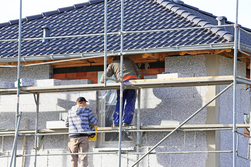 Workers insulating a house