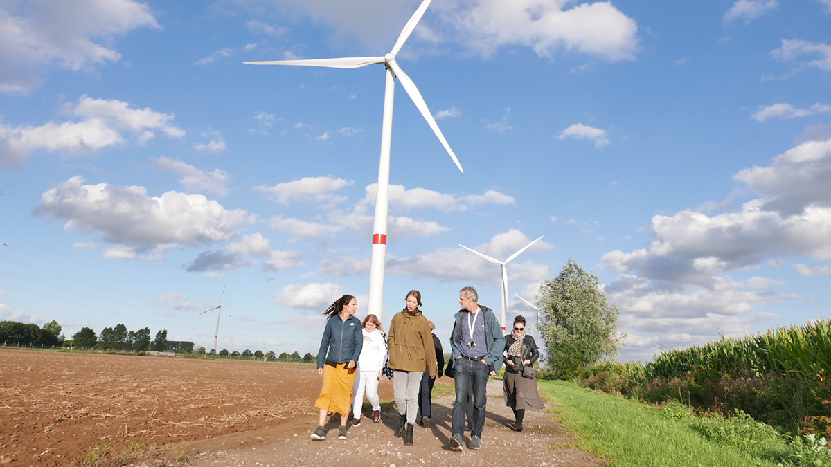 Citizens walking in front of a wind turbine